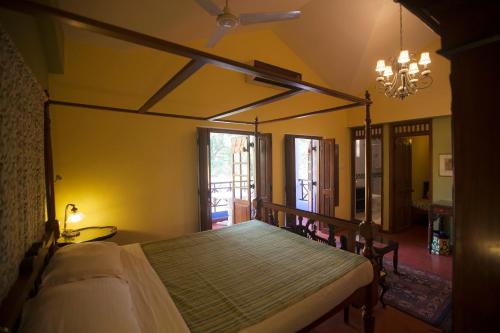 a bedroom with a bed and a chandelier at Presa di Goa - Managed by Smith and Appy in Calangute