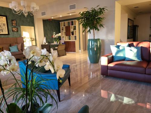a lobby with couches and flowers in a room at Sempione Boutique Hotel in Stresa