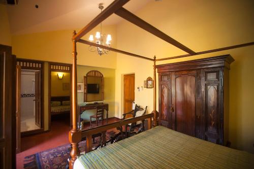 a bedroom with a bed and a desk and a mirror at Presa di Goa - Managed by Smith and Appy in Calangute