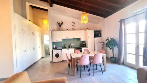 a kitchen with a dining table and pink chairs at Lovely 1BR in Old Town - City Center & 4min to Beach in Scala