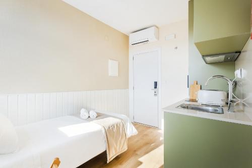 a white kitchen with a bed and a sink at Metropolitan Living Lisbon - Campolide in Lisbon