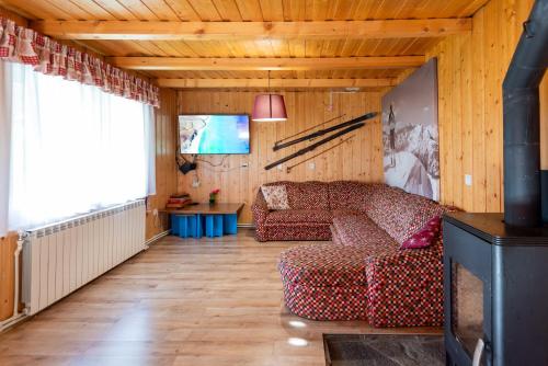 a living room with a couch and a tv at Natura BH in Izvoare
