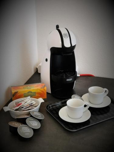 a coffee pot and cups on a table with a tray at Casa Belfiore Vicenza Medici 23 in Vicenza