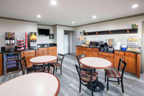 a restaurant with two tables and chairs and a kitchen at Days Inn by Wyndham Baytown TX in Baytown