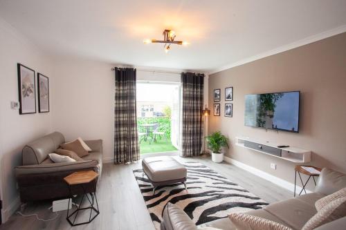 a living room with a couch and a tv at Modern 3 Bed Flat Balloch in Jamestown