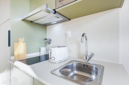 a kitchen counter with a sink and a appliance at Metropolitan Living Lisbon - Campolide in Lisbon