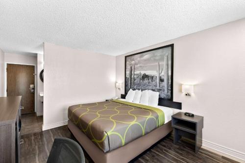 a hotel room with a bed and a desk at Super 8 by Wyndham Goodyear/Phoenix Area in Goodyear