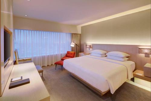 a bedroom with a large bed and a red chair at Hyatt Regency Mexico City in Mexico City