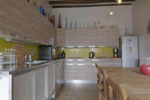 Il comprend une cuisine équipée d'une grande table et d'un réfrigérateur. dans l'établissement Ecologite La Rivière, à Éancé