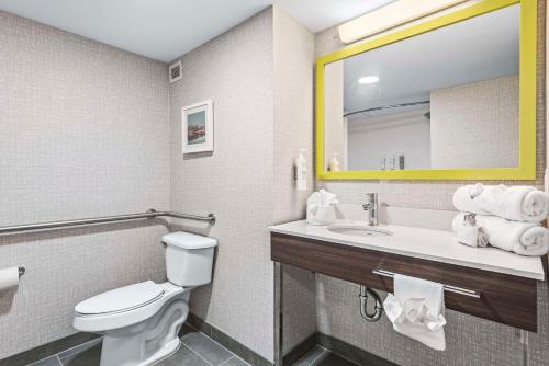 a bathroom with a toilet and a sink with a mirror at Hampton Inn Columbus-North in Columbus