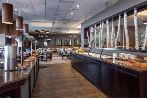 a restaurant with a bar with tables and chairs at Hilton St. Louis at the Ballpark in Saint Louis