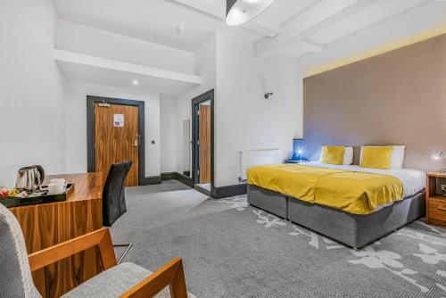 a hotel room with a bed and a desk at The Ainscow Hotel in Manchester