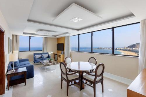 a living room with a table and chairs at Hilton Copacabana Rio de Janeiro in Rio de Janeiro