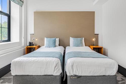 two beds sitting next to each other in a room at The Ainscow Hotel in Manchester
