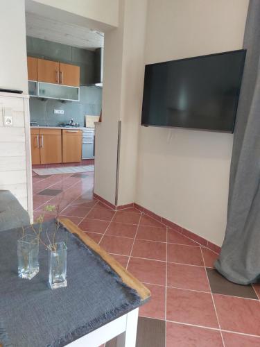a kitchen with a tiled floor with a television on a wall at Hotel Kapelle Bed & Breakfast in Bad Liebenstein