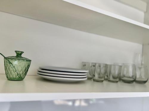 a shelf with plates and a vase and glasses at Departamento Funcional ll Punto Alquiler in Santiago del Estero