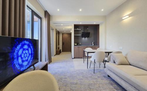 a living room with a couch and a table with chairs at Griffin Hotel in Tbilisi City