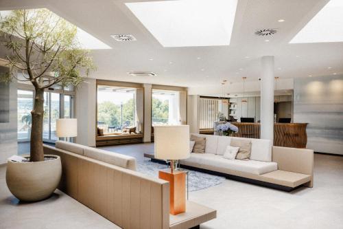 a living room with a couch and a tree at Heilthermen Resort Bad Waltersdorf in Bad Waltersdorf