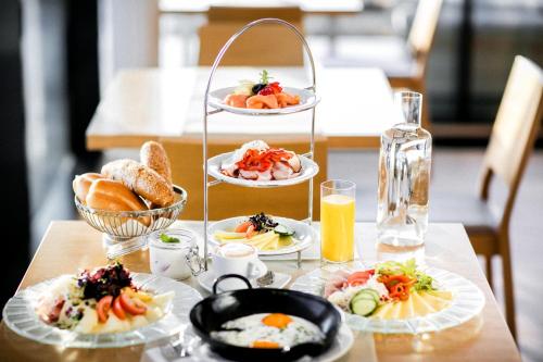 a table with plates of breakfast food on a table at Heilthermen Resort Bad Waltersdorf in Bad Waltersdorf