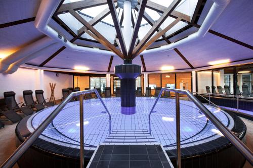 a large pool with a table in a building at Heilthermen Resort Bad Waltersdorf in Bad Waltersdorf