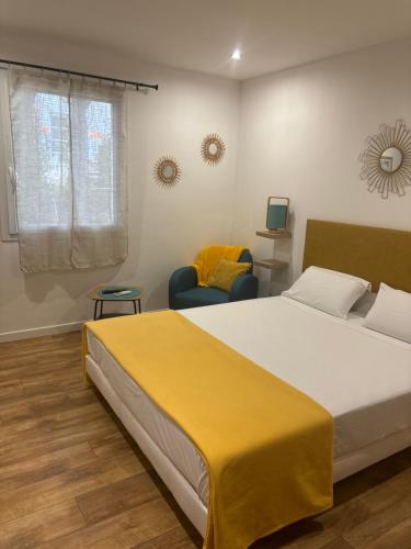 a bedroom with a large bed with a yellow blanket on it at La madone in La Tour-dʼAigues