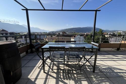 une table et des chaises sur un balcon avec vue dans l'établissement Penthouse flat South-facing terrace - Welkeys, à Annecy