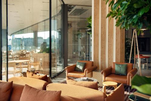 a lobby with couches and chairs and a table at Solo Sokos Hotel Pier 4 in Helsinki