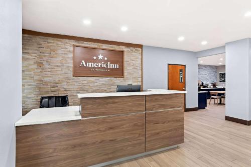 an office with a reception desk and a restaurant at AmericInn by Wyndham New Braunfels in New Braunfels