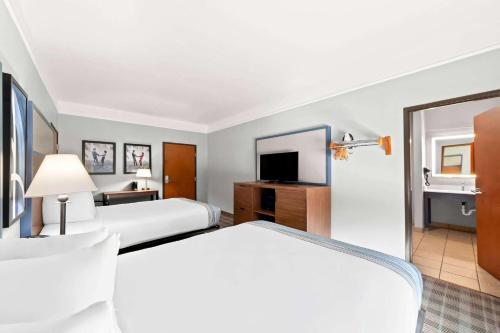 a hotel room with two beds and a television at AmericInn by Wyndham New Braunfels in New Braunfels