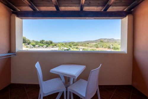 a table and chairs in a room with a large window at Hotel Sa Pedra in Murta Maria