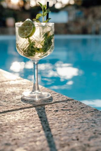 a glass with a plant in it next to a pool at Hotel Sa Pedra in Murta Maria
