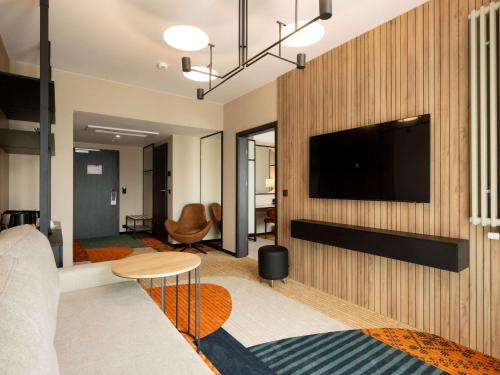 a living room with a flat screen tv on a wall at Mercure Szczyrk Resort in Szczyrk