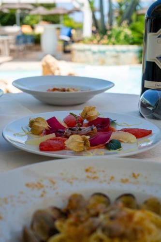 two plates of food on a table with a bottle of wine at Hotel Sa Pedra in Murta Maria