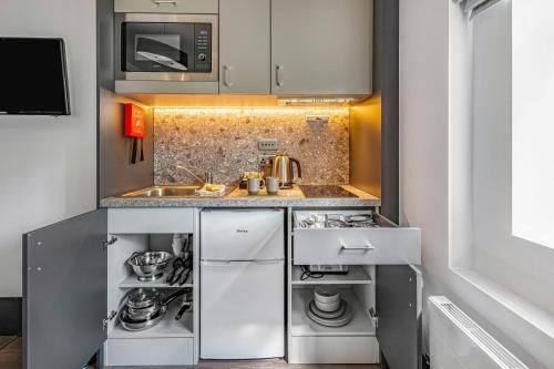 a small kitchen with a sink and a stove at The Ainscow Hotel in Manchester