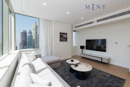 a living room with a white couch and a large window at Sky Gardens, Park Avenue, DIFC - Mint Stay in Dubai