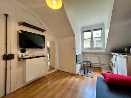 un salon avec une télévision à écran plat au mur dans l'établissement Studio au proche du louvre, à Paris