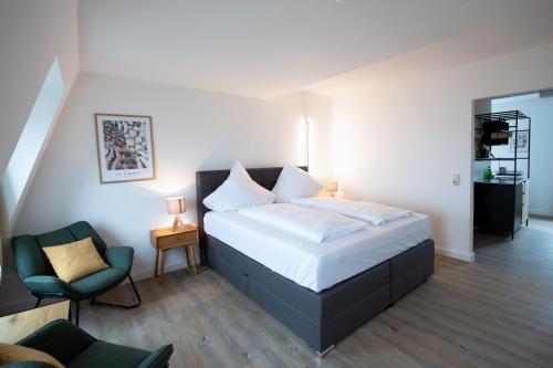 una camera da letto con un letto grande e una sedia di Pension Seeblick a Barth