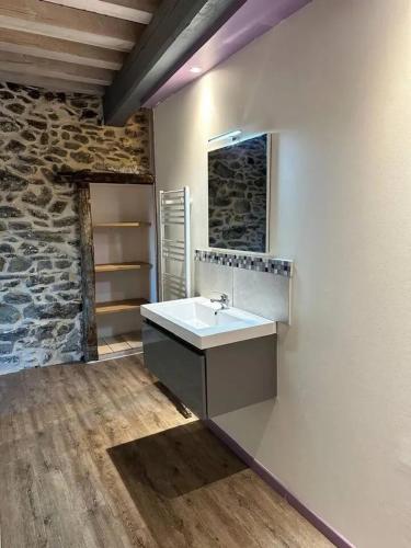 une salle de bain avec un lavabo et un mur en pierre dans l'établissement Chalet confortable à Ascou avec vue sur la montagne, à Ascou