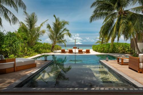 a swimming pool with a view of the ocean at Huvafen Fushi Maldives in North Male Atoll