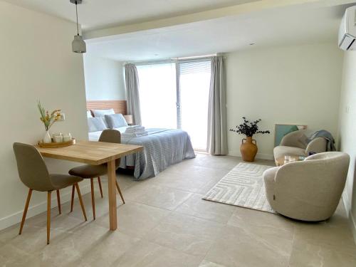 ein Wohnzimmer mit einem Bett und einem Tisch und Stühlen in der Unterkunft Zelfstandige Studio met Hottub in Merselo