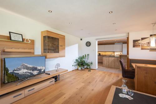 Una sala de estar con un televisor de pantalla plana grande. en Landhaus Kirchberg, en Kirchberg in Tirol
