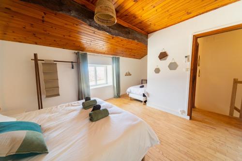a bedroom with a large bed with a wooden ceiling at Escapade en Val de Saône T4 familial & jardin in Thoissey