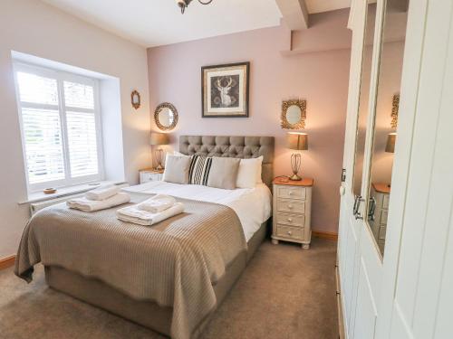 a bedroom with a large bed with two towels on it at The Mounting Steps in Ambleside
