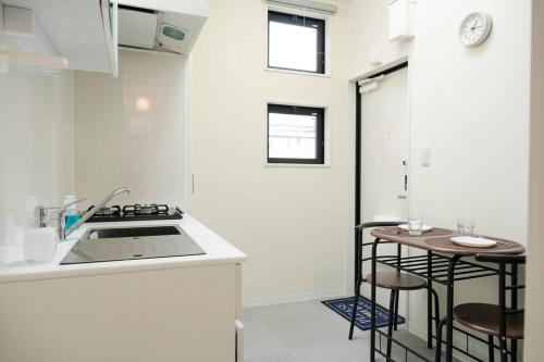 a kitchen with a sink and two bar stools at new!門前仲町 越中島から徒歩5分! 銀座 浅草 スカイツリー 築地 豊洲 舞浜へアクセス良好 in Tokyo