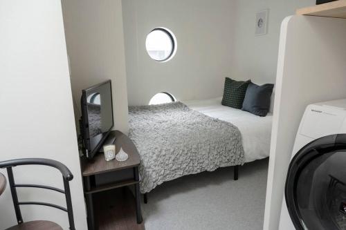 a small bedroom with a bed and a television at new!門前仲町 越中島から徒歩5分! 銀座 浅草 スカイツリー 築地 豊洲 舞浜へアクセス良好 in Tokyo