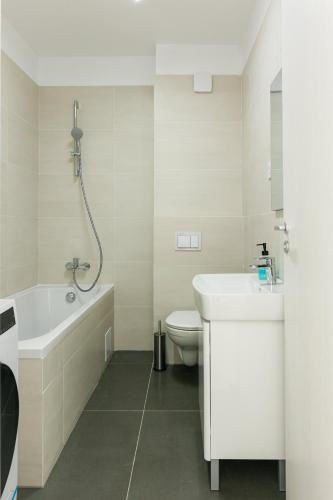 a bathroom with a tub and a sink and a toilet at Thirty Six Apartment in Bistriţa