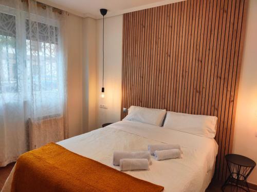 a bedroom with a large bed with two towels on it at VuT La Casita del Cuéntame in Burgos