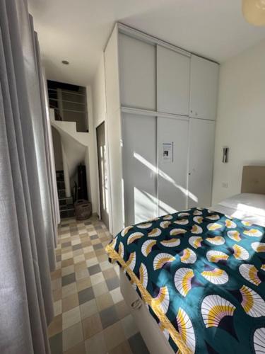 une chambre avec un lit avec une couette colorée dans l'établissement Charming T2 near beach of Trouville-sur-Mer, à Trouville-sur-Mer