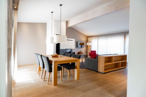 a dining room and living room with a table and chairs at Das.Hochgrat in Oberstaufen