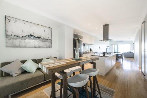 a living room and kitchen with a couch and a table at Oceans View - Luxury Apartment with ocean views in Lancelin